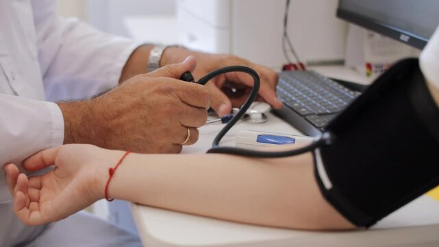 Doctor Measuring Blood Pressure with Arm Cuff