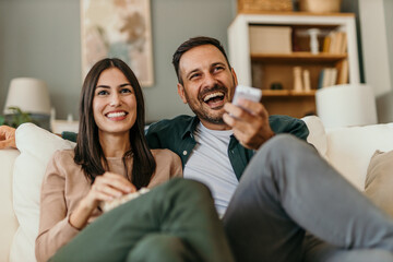 Adult couple boyfriend and girlfriend watch movie with popcorn at home