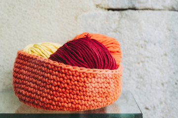 Joli panier en laine tricoté main de couleur orange avec des pelotes de laine © PicsArt