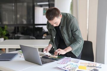 Business asian Man Artist Creative Designer sketch graphic drawing on graphic laptop and Color swatch samples Concept of idea creativity