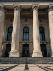 Obraz premium a grand neoclassical government building with imposing marble columns, a triangular pediment, and wide stone steps leading to its entrance