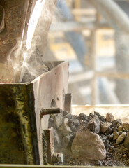 Cement factory. A conveyor with stones and gravel undergoes the crushing process. Modern technologies at a cement plant. Technological work for cement production. Close-up of raw material grinding.