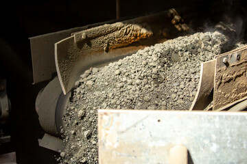 Cement factory. A conveyor with stones and gravel undergoes the crushing process. Modern...