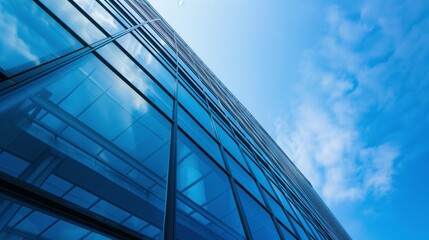 Obraz premium Modern Glass Building Facade with Blue Sky Reflection - Contemporary Urban Architecture Photograph