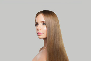 Fototapeta premium Fashion portrait of young woman model with modern make-up and long straight smooth hairstyle standing on white studio background