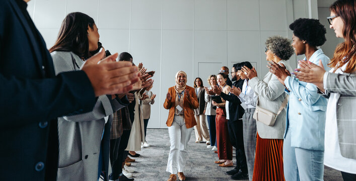 Corporate team building activity with diverse colleagues clapping and cheering during a conference