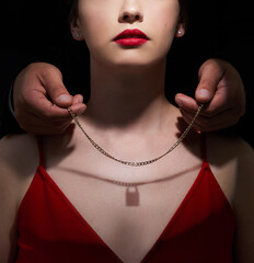 Necklace, lock and gift with couple in studio for toxic relationship, abuse and secret. Jewelry,...