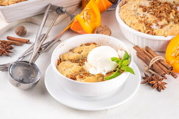 Homemade autumn pumpkin crisp cobbler, pumpkin crumble pie with crunchy dough topping in baking...