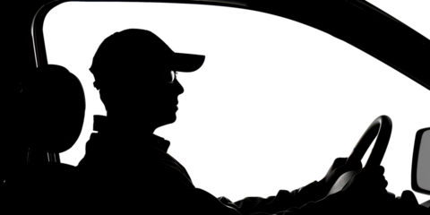 A man is driving a car with his hands on the wheel