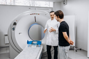 In a bright diagnostic center, a young man undergoes a CT or MRI scan using modern equipment. This...