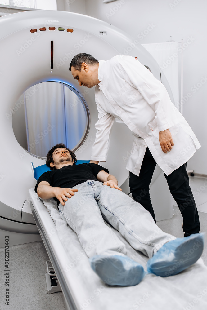 Wall mural in a modern diagnostic center, a young male patient undergoes an mri or ct scan with professionals b