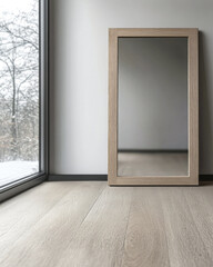 Modern wooden mirror reflecting natural light in a minimalist room with large window and wooden flooring