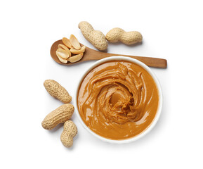 Tasty peanut butter in bowl, spoon and groundnuts isolated on white, top view