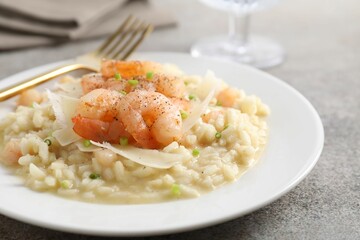 Delicious risotto with shrimps and cheese on grey table, closeup