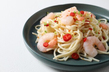 Delicious pasta with shrimps, green onion and chili pepper on white table, closeup