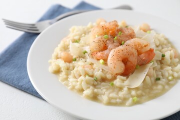 Delicious risotto with shrimps and cheese on white table, closeup