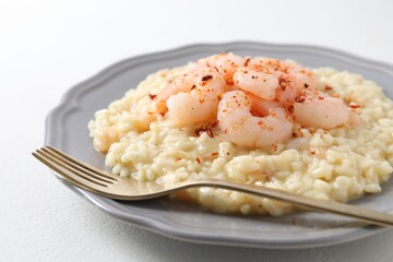Delicious risotto with shrimps and cheese on white table, closeup