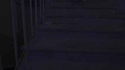 Creepy ghost woman in dress sitting alone on staircase in dark haunted house holding smartphone chroma key green screen. Halloween horror advertisement concept.