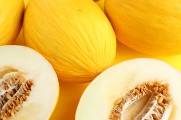 Whole and cut ripe melons as background, closeup