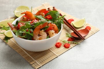 Delicious shrimp salad with vegetables in bowl served on grey table