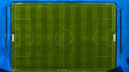 Perpendicular aerial view of a natural turf soccer field. The sports facility is empty.