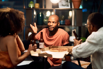 Happy friends, beer and business people talk in office to celebrate Octoberfest party. Alcohol, drink or African team eating pizza or food at social event after deadline in creative startup at night