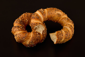 pretzel with mixed seeds on a table on a black background