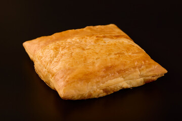 (Merdenea) pie with cheese on a table on a black background.