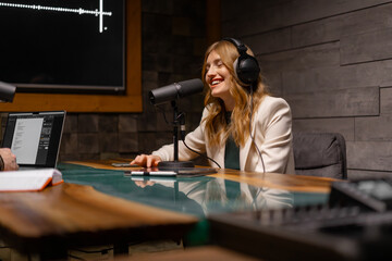 A woman is equipped in a studio to record a podcast professionally with modern audio technology