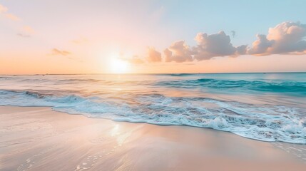Obraz premium Sunset over a Turquoise Ocean and Sandy Beach.