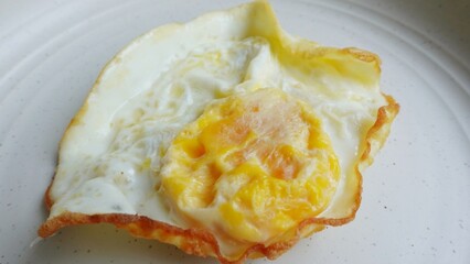 Cooked sunny side up eggs on a white plate ready to be enjoyed. Breakfast menu illustration.