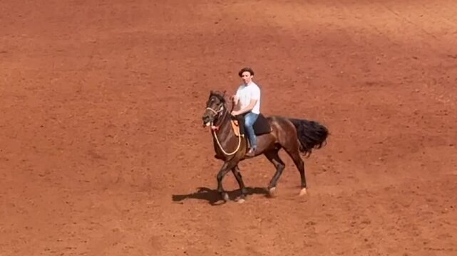 homem cavalga com cavalo em arena rural 