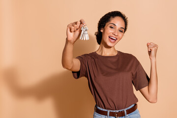 Photo of glad cheerful nice woman wear stylish clothes hold buy new house empty space isolated on beige color background