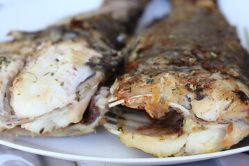 A plate filled with fish smothered in savory sauce, perfect for a meal or dinner occasion