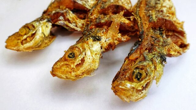 Close up photo of crispy fried Selar fish or Selaroides leptolepis. Protein food Isolated on a white background.