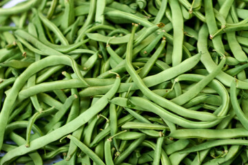 Detailed image of fresh green beans with a focus on their texture and intense color. Excellent for representing themes of healthy eating, organic products, and gourmet cooking.