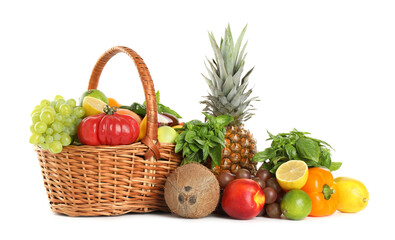 Different fresh fruits and vegetables in wicker basket isolated on white