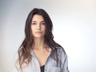 Fototapeta premium Fashion, portrait and girl in studio, trendy and stylish in mockup, proud and clothes for stylist. Confident, model and woman with hairstyle, retail and aesthetic of person, serious and shirt in USA