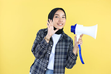 Young Asian Indonesian Muslim woman in Headscarf  Veil Hijab Speaking Through Megaphone