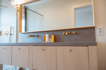Modern minimalist bathroom with gold faucets and large mirror