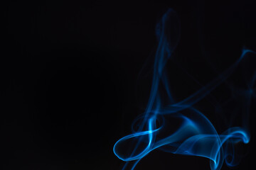 Blue smoke isolated on a black background. A thin curved line of smoke, steam from a burnt candle to overlay on your photos