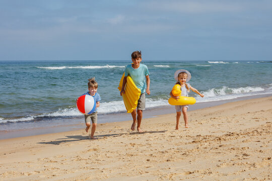 Kids enjoy sunny summer day with inflatables and a beach ball