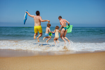 Family jumping at the beach, poised for a day of sun and fun