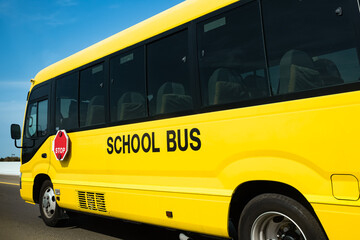 Yellow school bus coming to drop off students at the bus stop in a residential area. Dubai school...