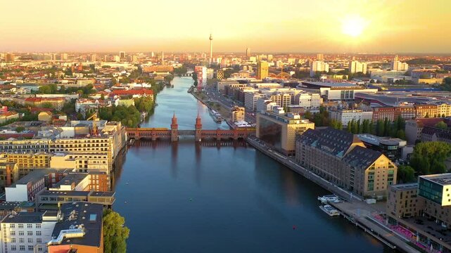 City of Berlin, Germany from above. Aerial cityscape view showing architectural landmarks Oberbaum Bridge, TV Tower and Berlin Cathedral at sunset. Drone flight on the river Spree.