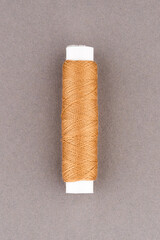 Brown thread spool close-up macro flat lay top view.