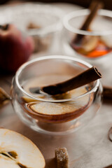 apple tea in glass cups with red apple slices and cinnamon stick, autumn tea, autumn drink, tea with brown cane sugar, autumn composition, fruit tea