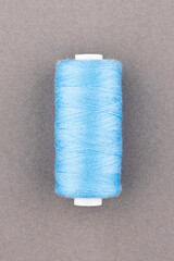 Blue thread spool close-up macro flat lay top view.