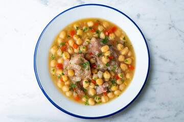 Chickpea stew with pig trotters. Top view table with  decorations.
