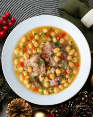 Chickpea stew with pig trotters. Top view table with Christmas decorations.